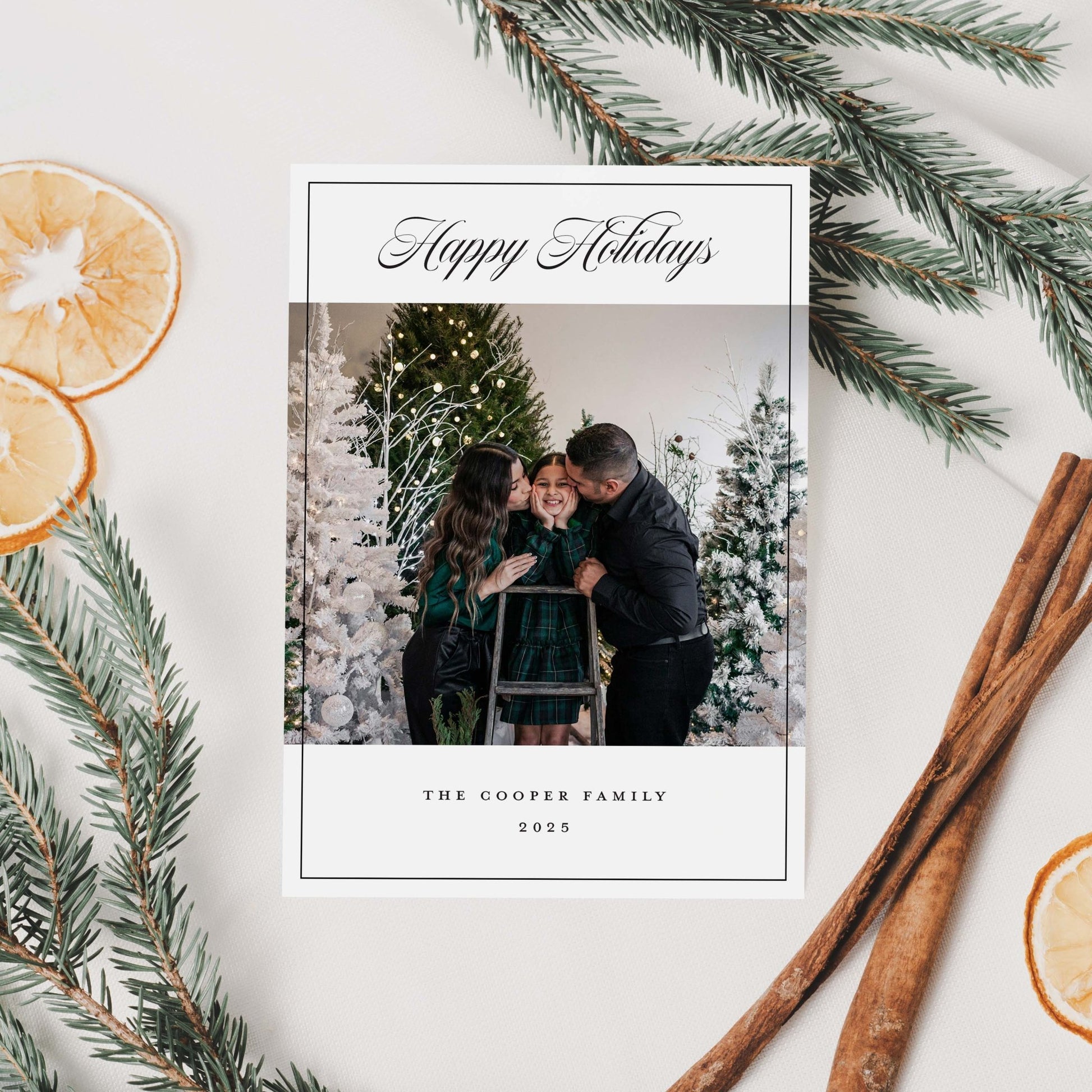 Holiday card with family photo, 'Happy Holidays' text, and decorative elements like cinnamon sticks and oranges.