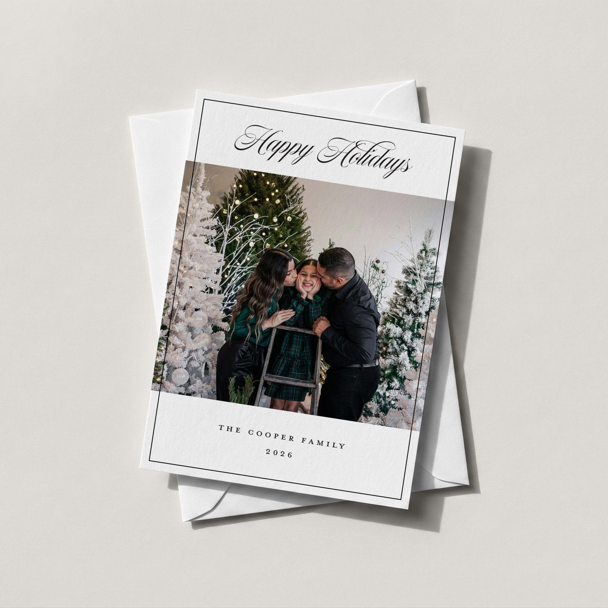 Cooper Family Chic photo holiday card in white with Happy Holidays script and a family photo, on a white envelope