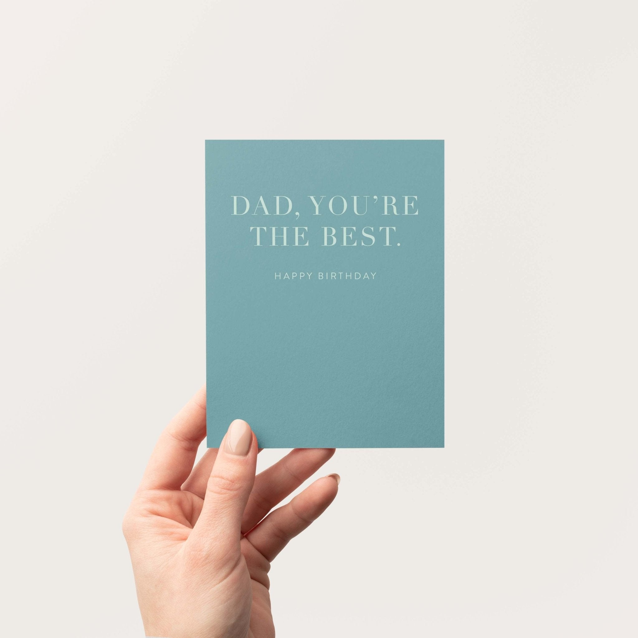 Dad You're the Best birthday greeting card by Blú Rose held in hand against a neutral off-white background