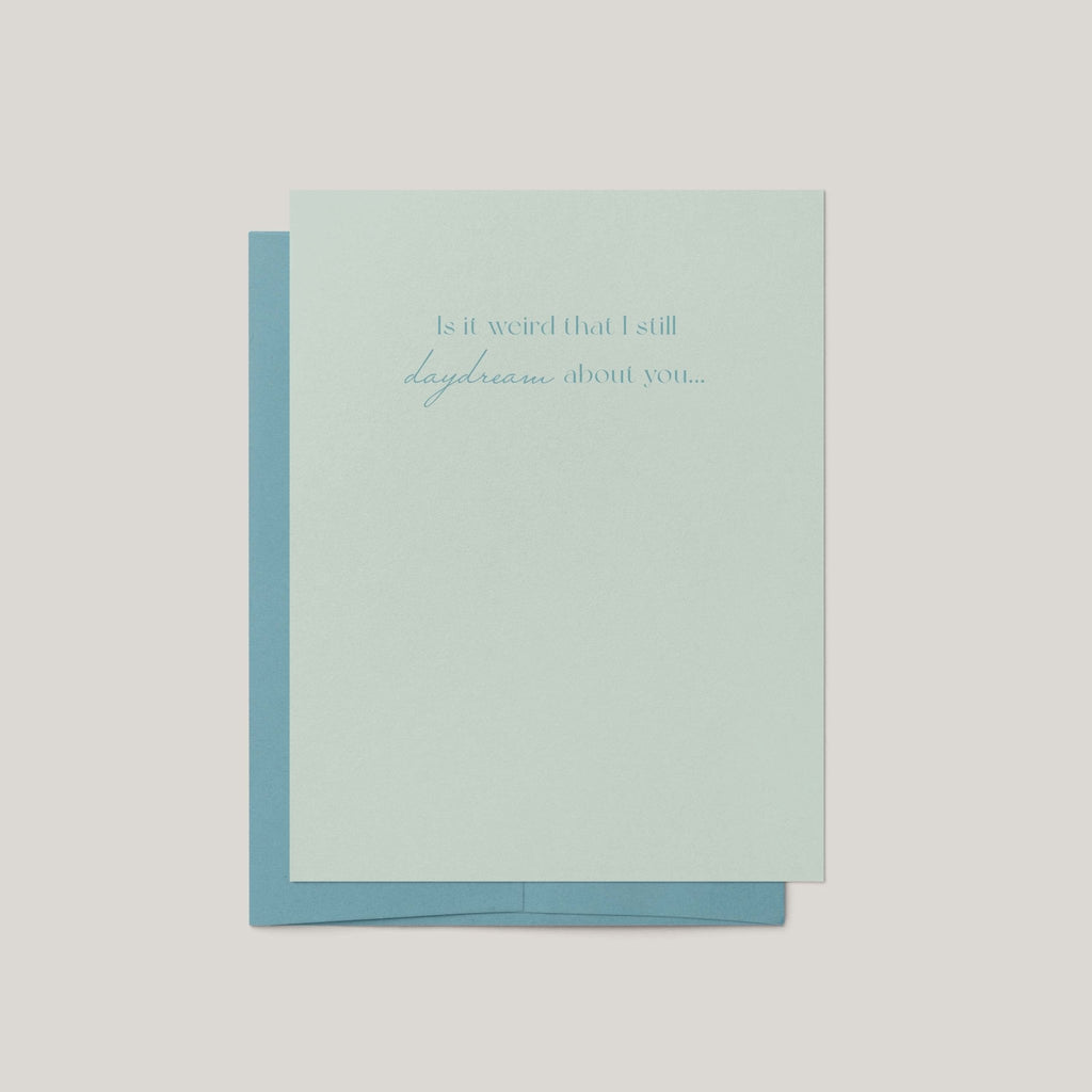 A pale mint green greeting card with a light blue envelope behind it, centered on a light gray background. The card has a small printed phrase in blue script at the top.