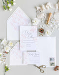 Delicate Floral wedding invitation suite by Blú Rose, invitation and reply card with fine rose-gold line florals, styled with floral-lined envelopes, ribbon, and a wax seal