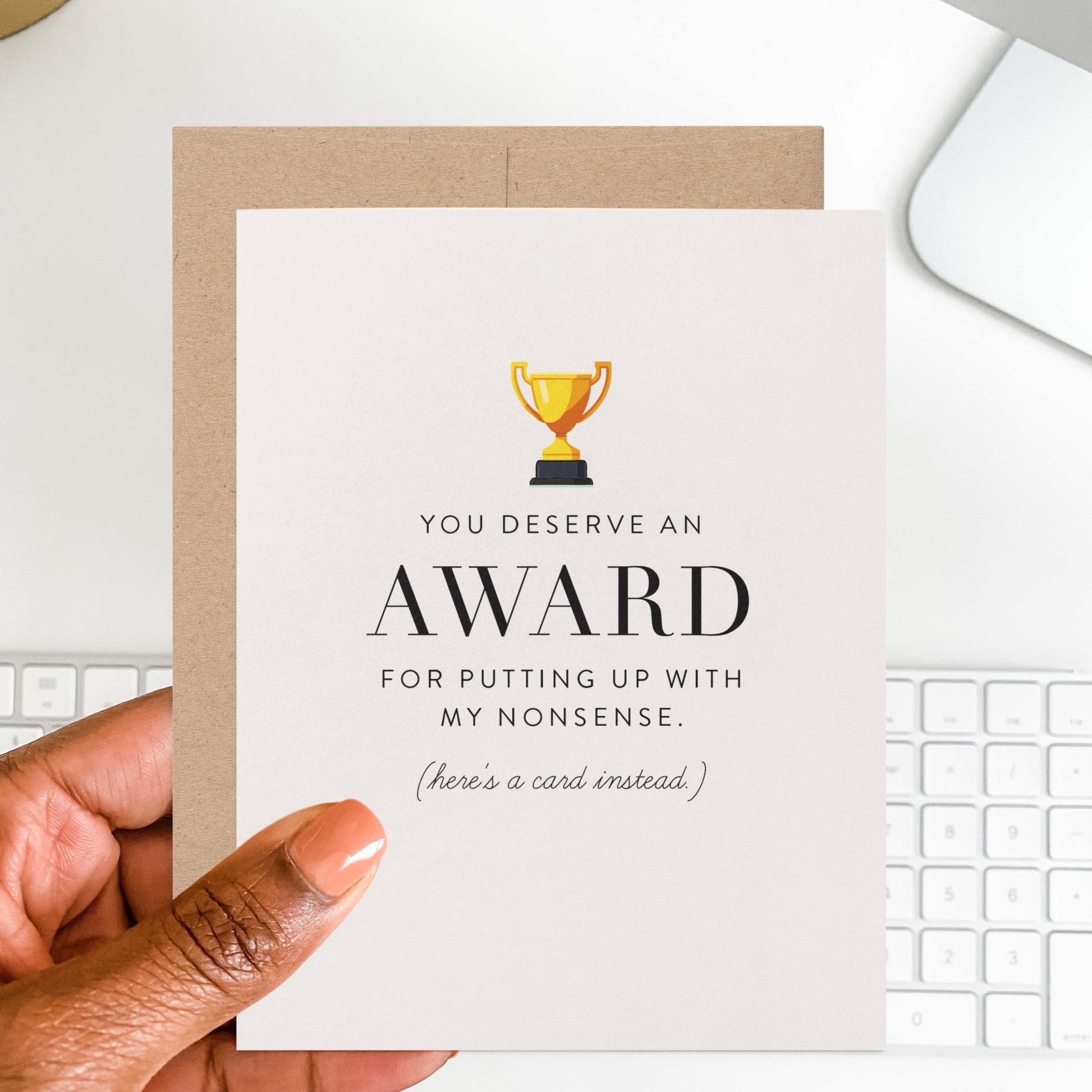 Hand holding humorous award card with gold trophy design