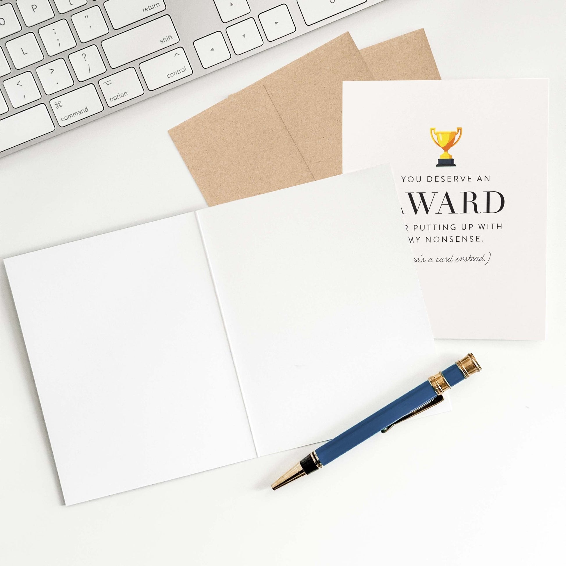 Award greeting card with open blank interior, envelope, and pen