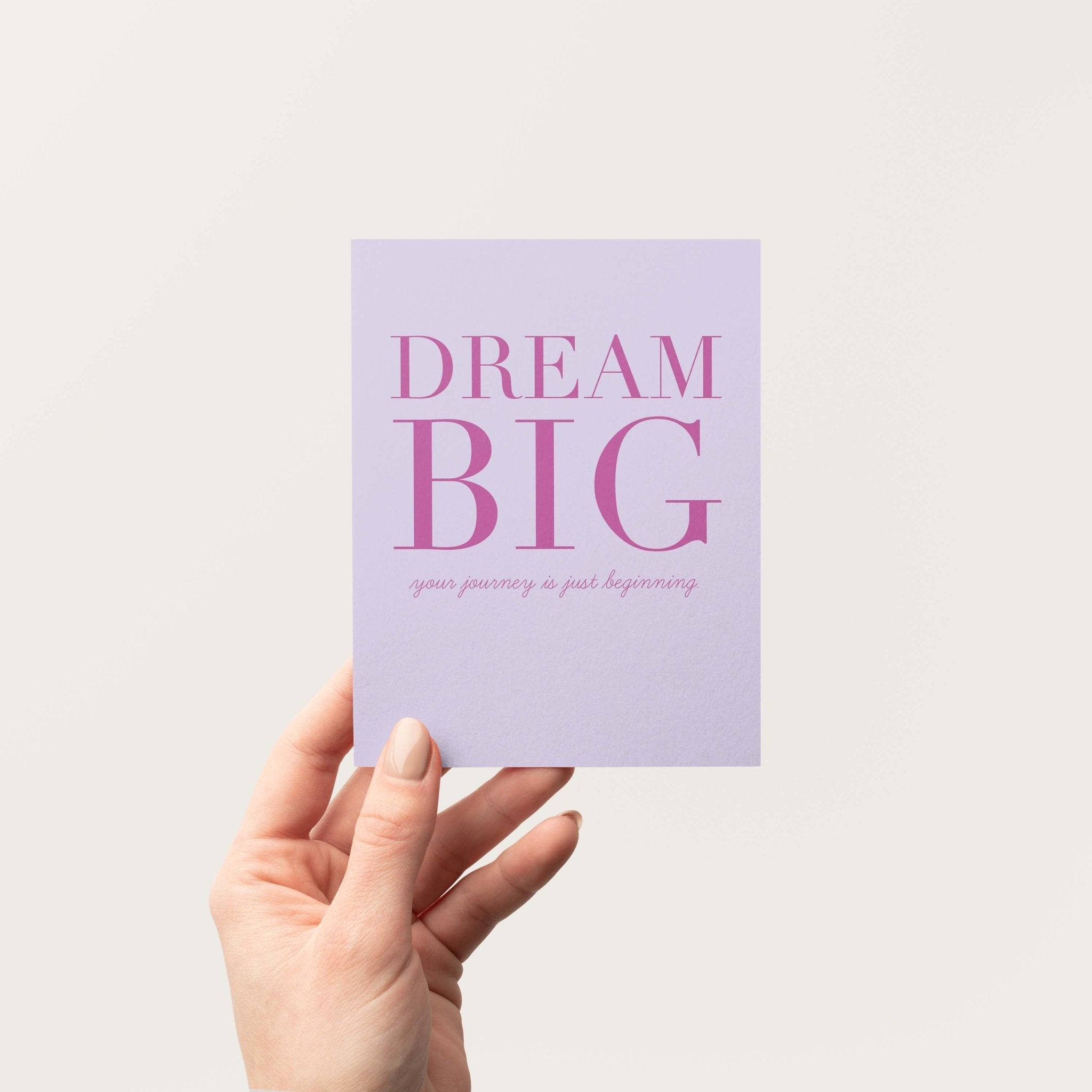 Dream Big graduation greeting card by Blú Rose held in hand against a neutral off-white background