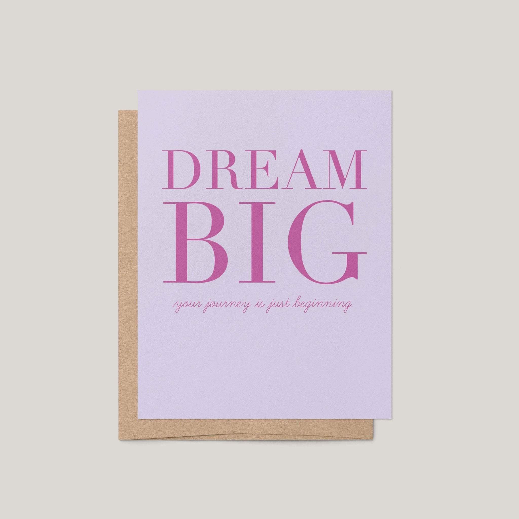 Dream Big graduation greeting card by Blú Rose, lavender card with magenta serif dream big text, shown with kraft envelope