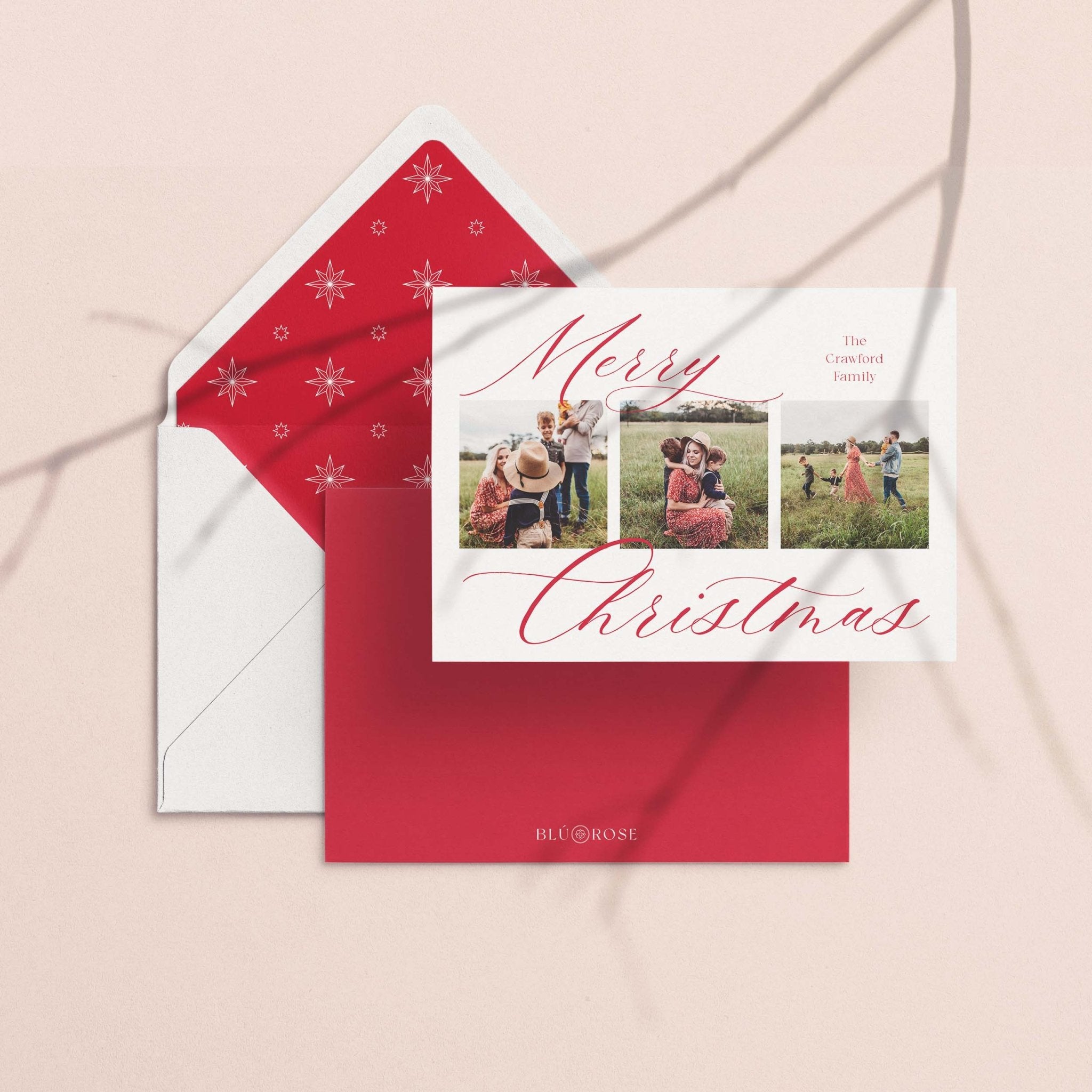 Elegant Three card with its red snowflake-print envelope liner styled on a blush backdrop