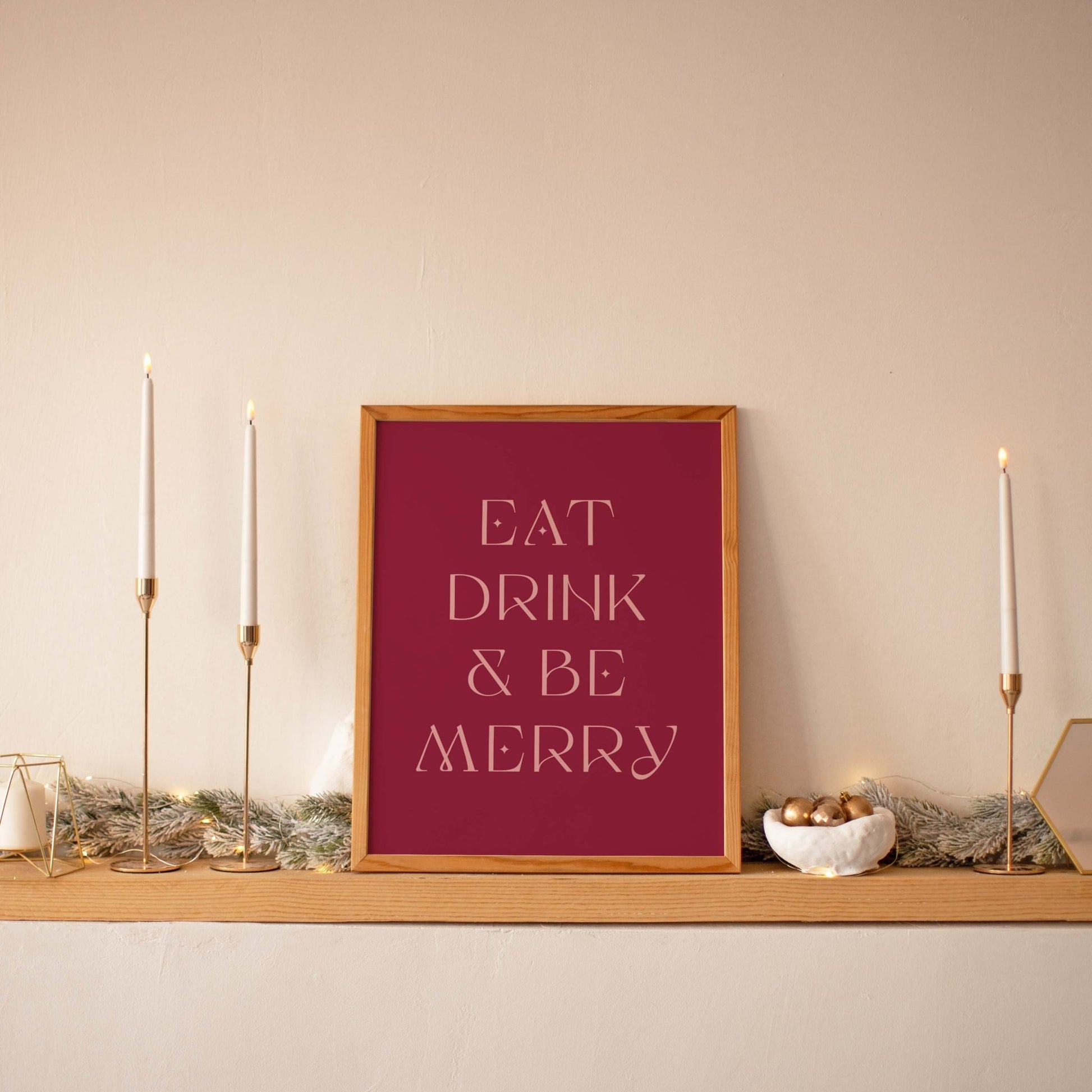 Festive Eat Drink & Be Merry wall art displayed on a shelf with taper candles and neutral decor