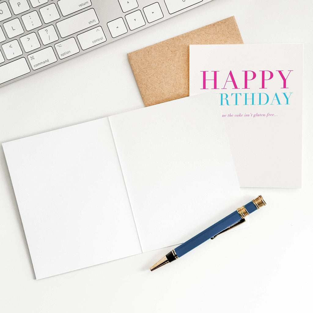 Gluten-Free Birthday card by Blú Rose shown open with blank interior, kraft envelope and pen on a white desk