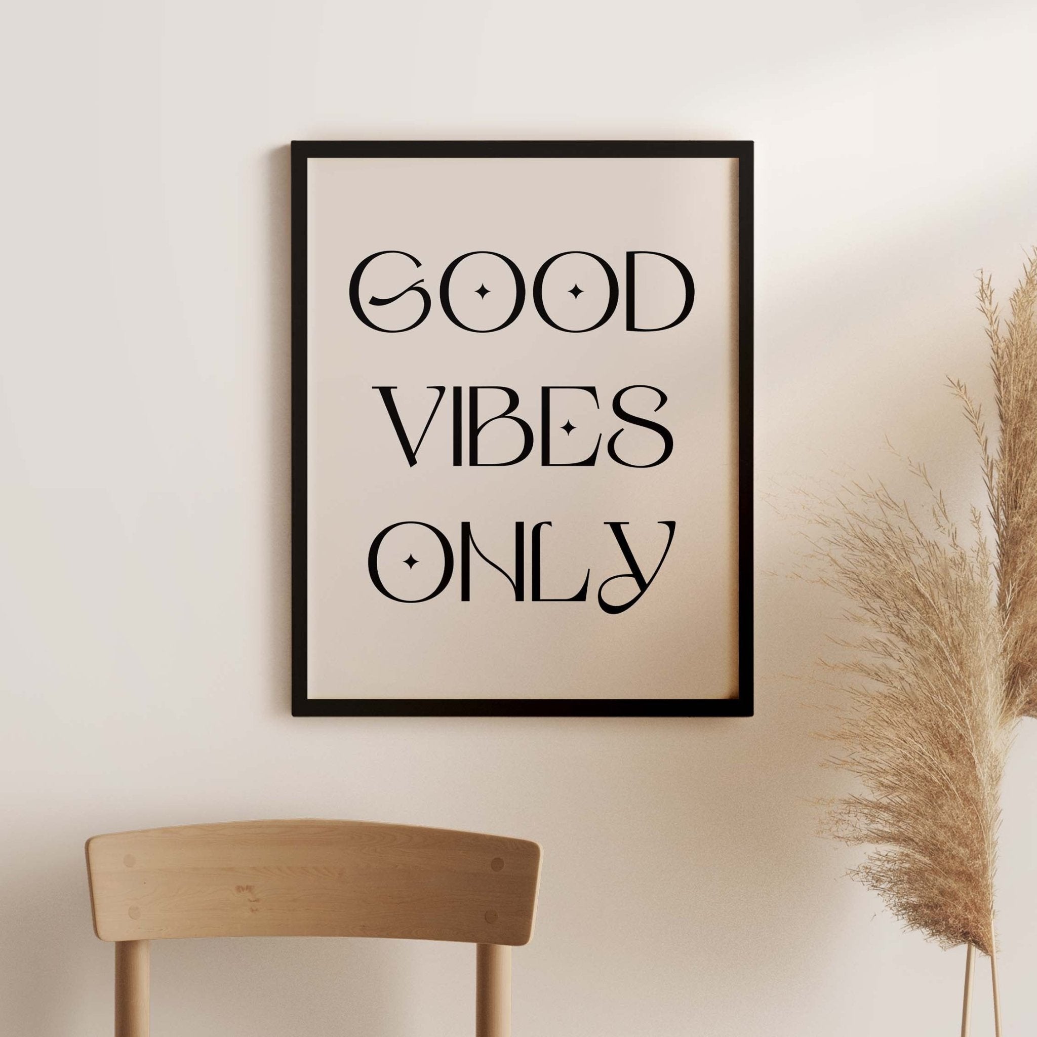 Good Vibes Only minimalist typography art print styled above wooden chair with neutral modern decor