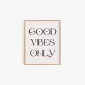 Good Vibes Only typography art print in black lettering on off-white background in natural wood frame