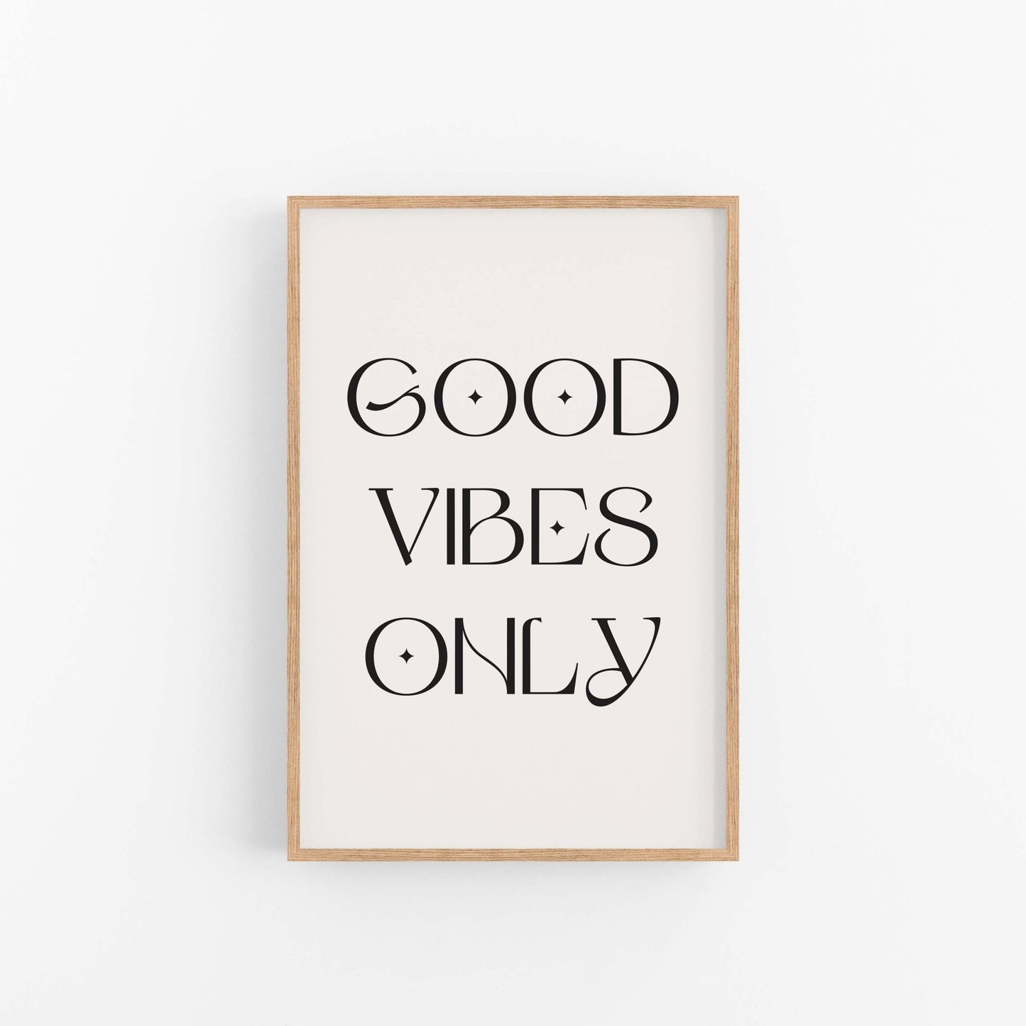 Good Vibes Only black typography wall art print on off-white background in light wood frame