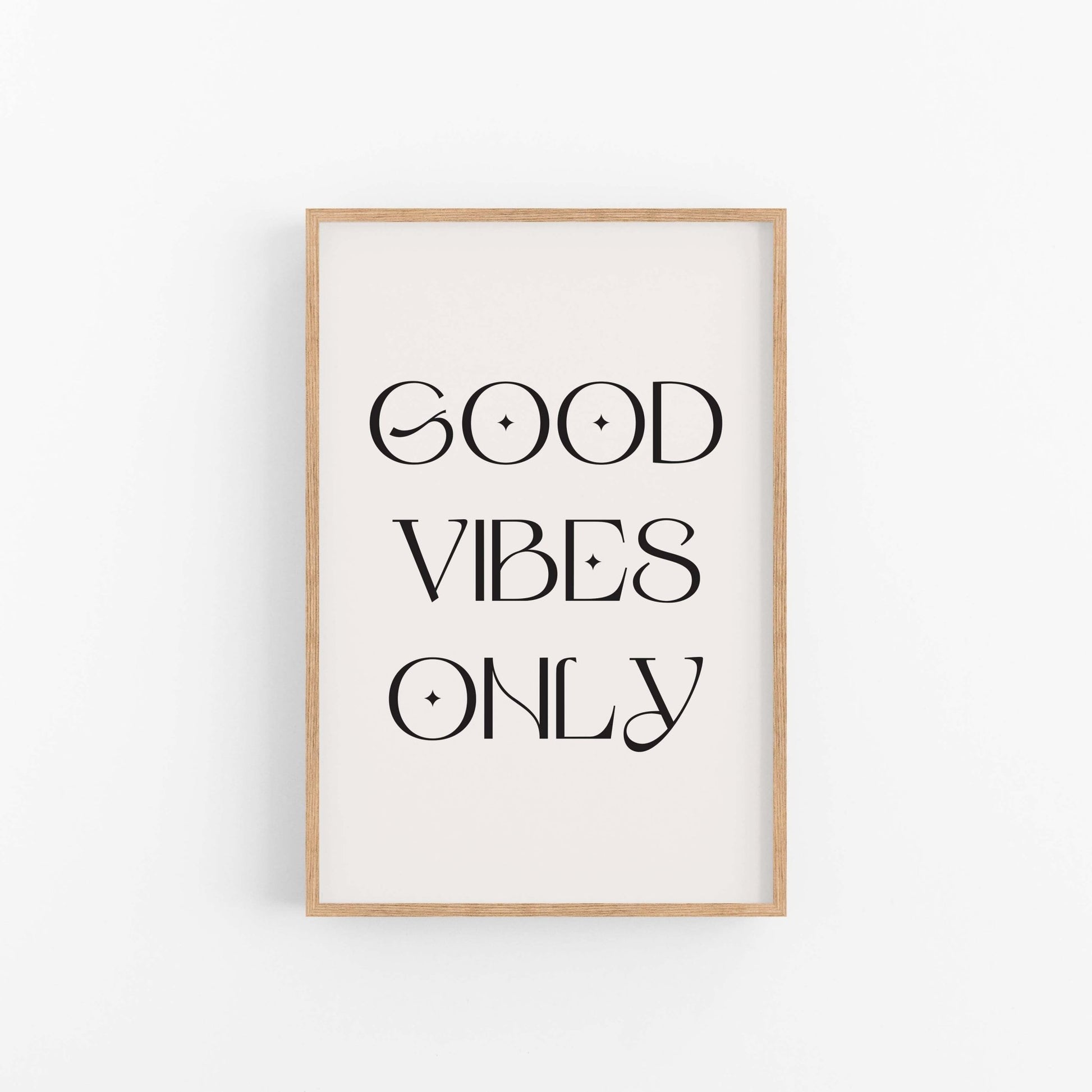 Good Vibes Only black typography wall art print on off-white background in light wood frame