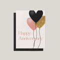 Greeting card with black, pink, and gold balloons and 'Happy Anniversary' text on a light gray background.