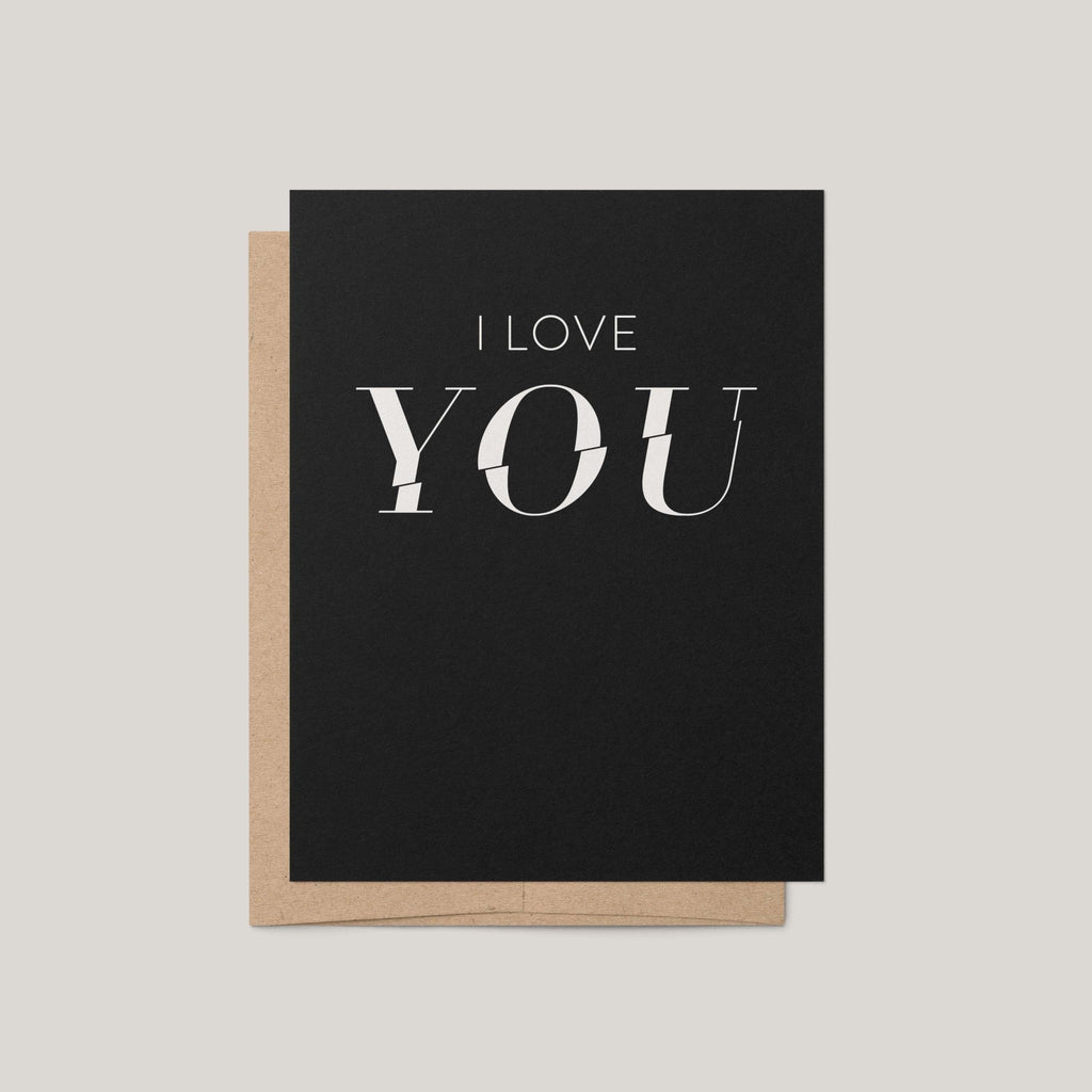 A black greeting card with the words 'I LOVE YOU' printed in white, shown with a brown kraft envelope on a light gray background.