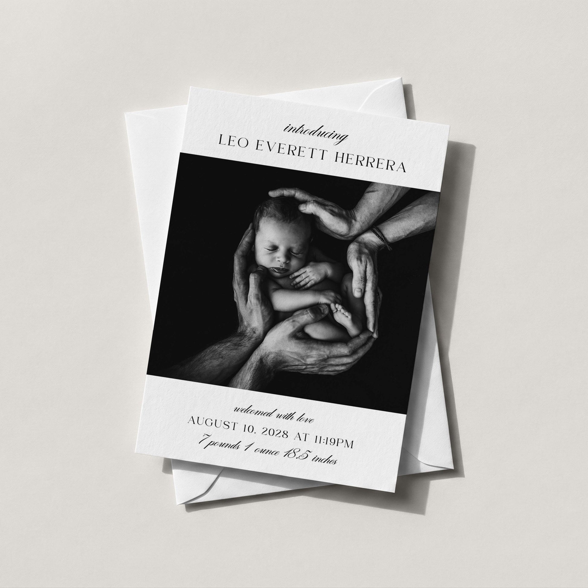 Introducing Me baby announcement card with full bleed newborn photo, elegant script and serif typography showing baby name, birth date, weight, and length