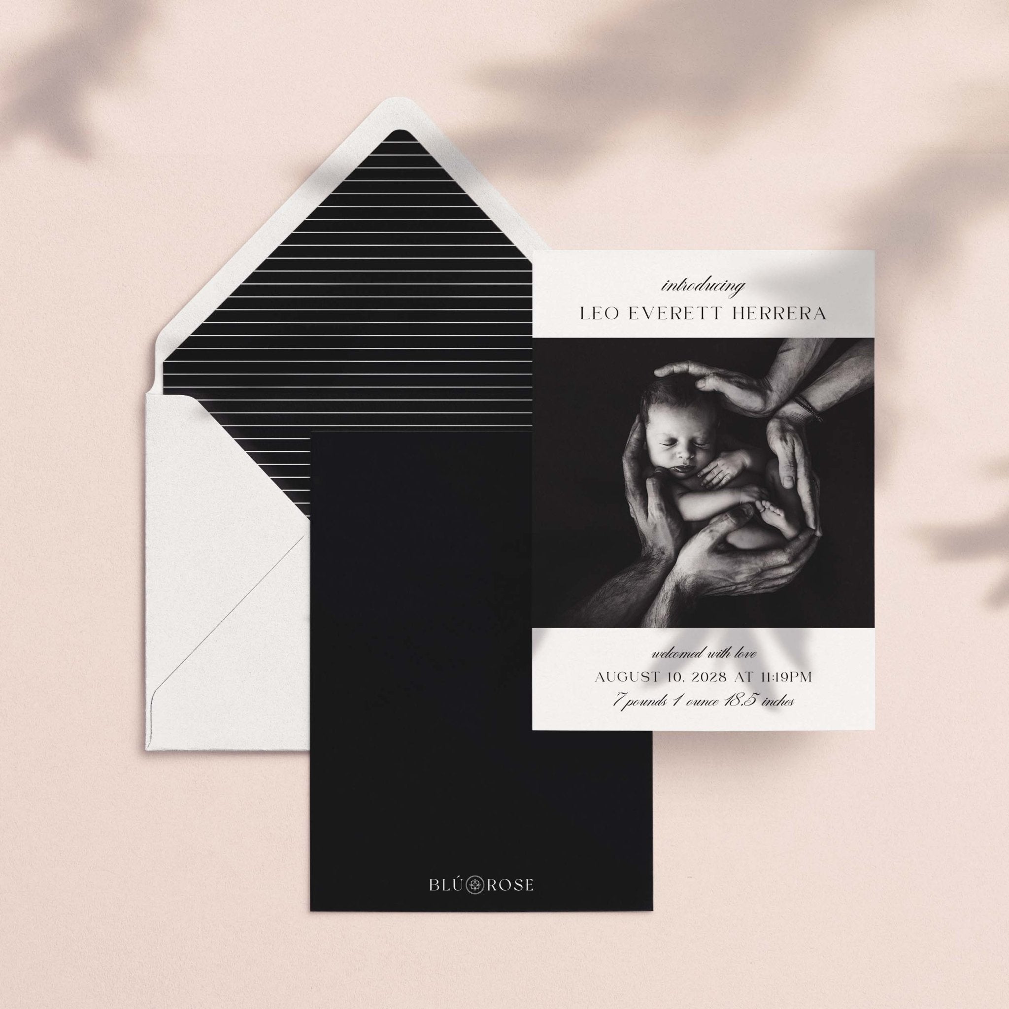 Introducing Me birth announcement card shown with black striped envelope liner and dark backer card on blush background