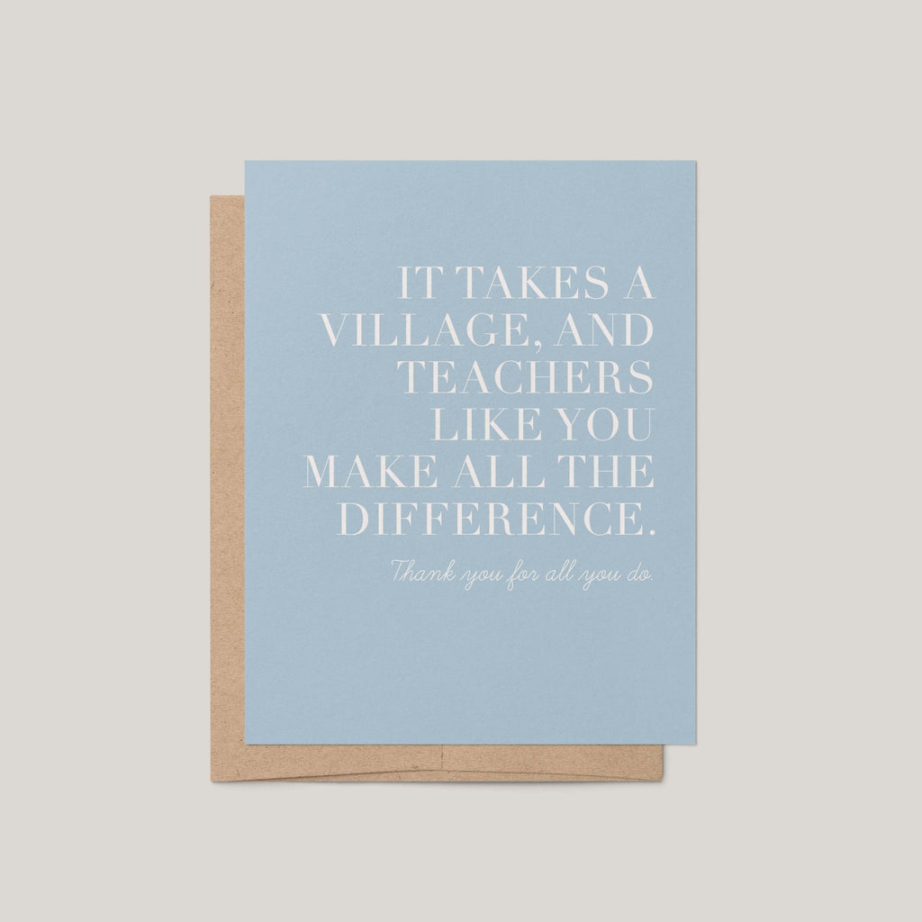 It Takes a Village teacher greeting card by Blú Rose in dusty blue with white serif text, shown with a kraft envelope