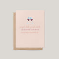 Jingle Bells & Wine funny holiday greeting card by Blú Rose, blush card with clinking red wine glasses illustration, shown with kraft envelope