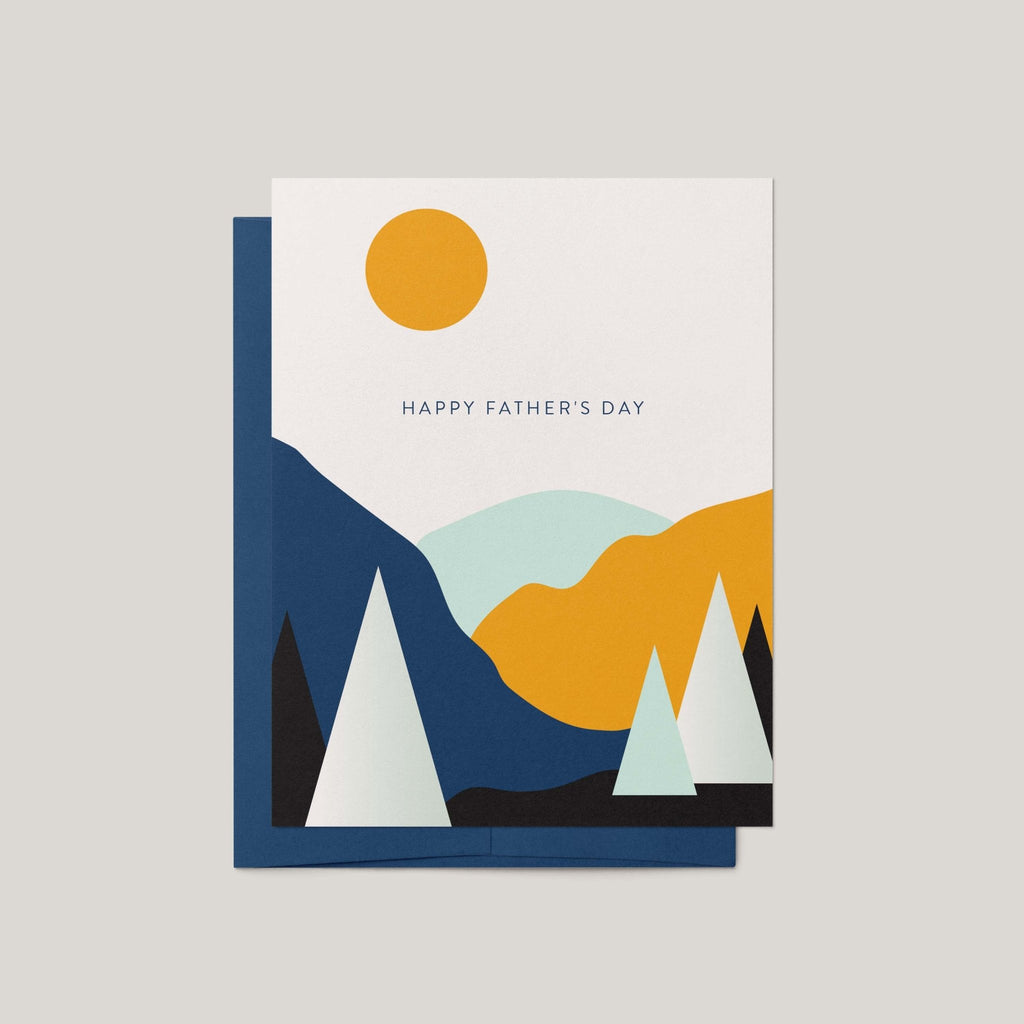 Landscape Father's Day greeting card by Blú Rose, white card with minimalist mountain and sun landscape and Happy Father's Day text, shown with navy envelope