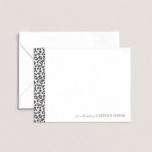 A white envelope with a black and white leopard print border, and a blank card with the name 'Caitlyn Davis' printed on it.