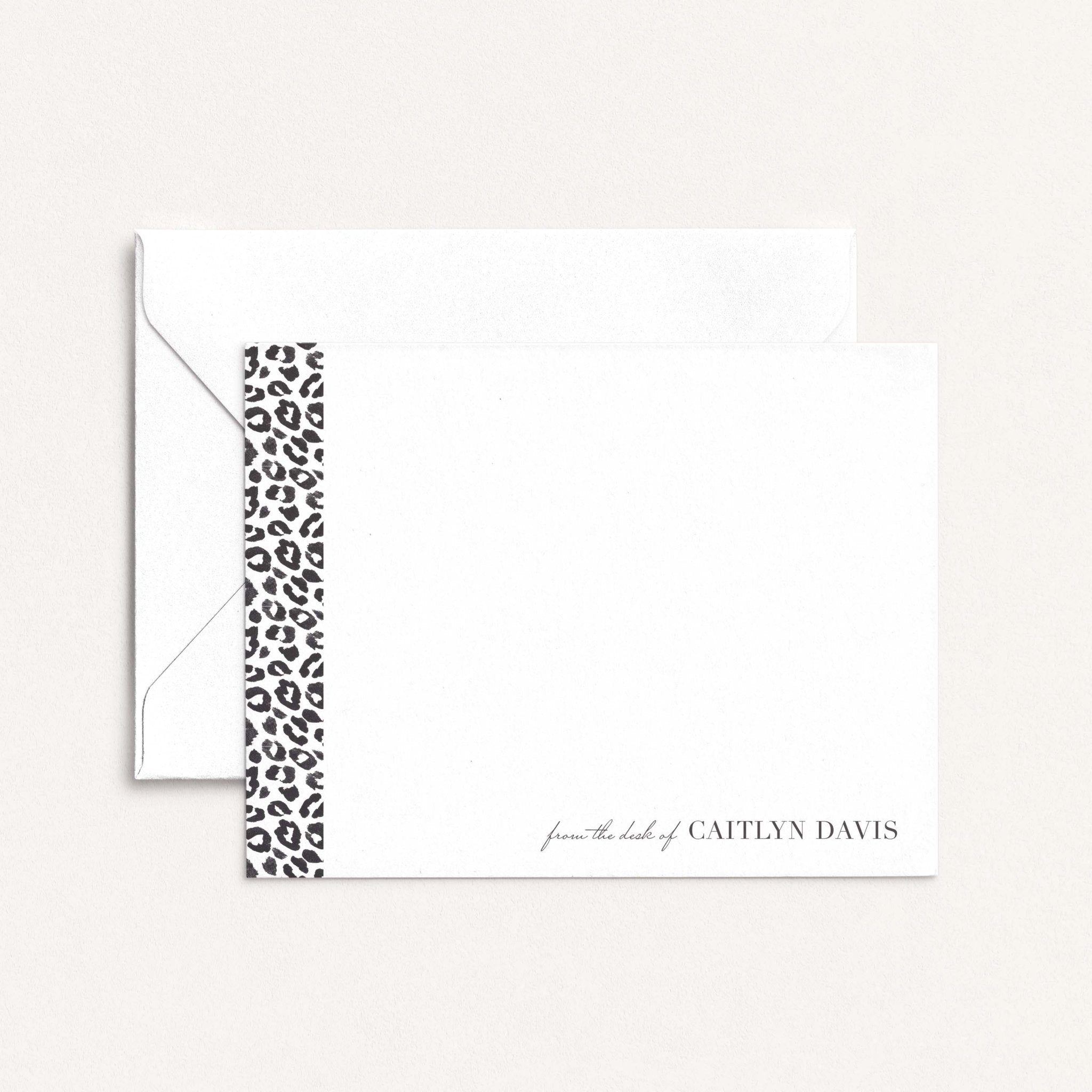 Leopard personalized notecards by Blú Rose, white flat notecard with a leopard-print side stripe and 'from the desk of Caitlyn Davis', shown with a white envelope