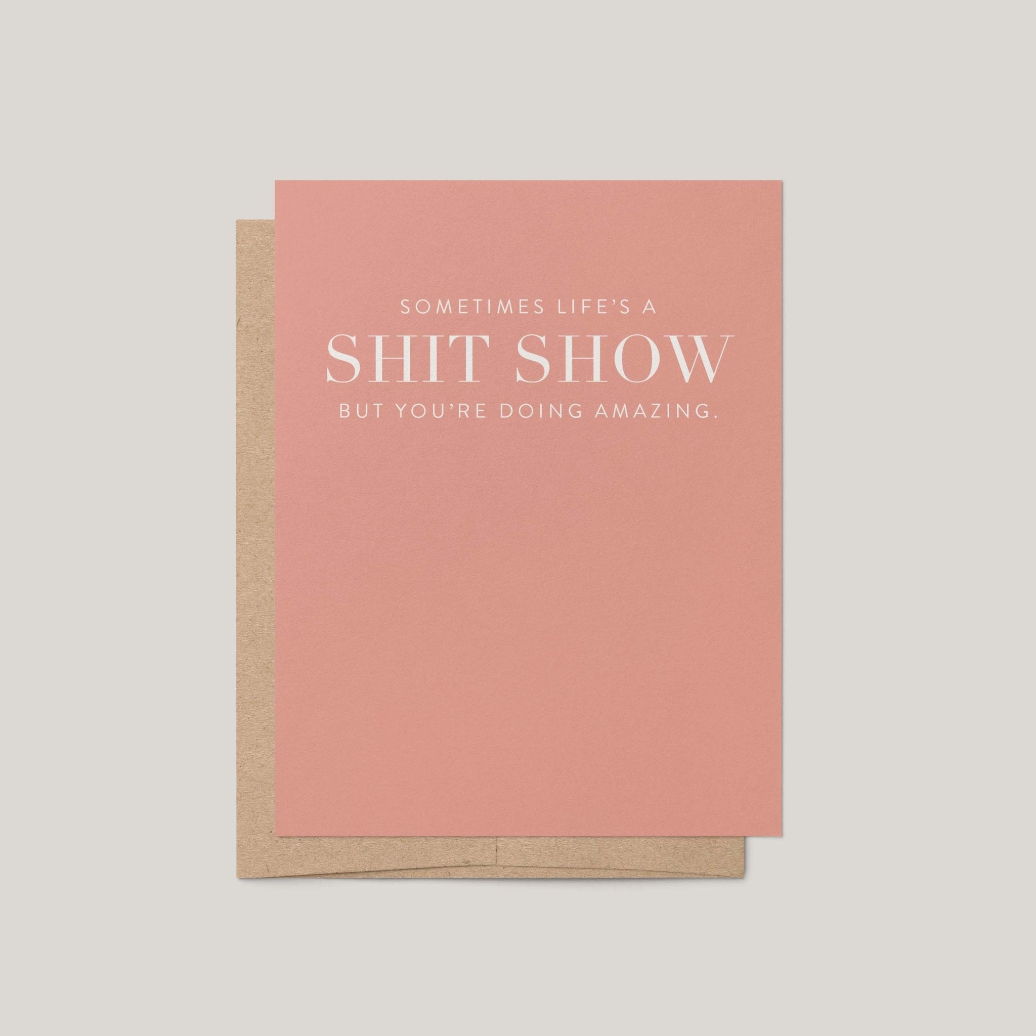 Life's A Shit Show funny encouragement greeting card by Blú Rose, mauve pink card with white serif text, shown with kraft envelope