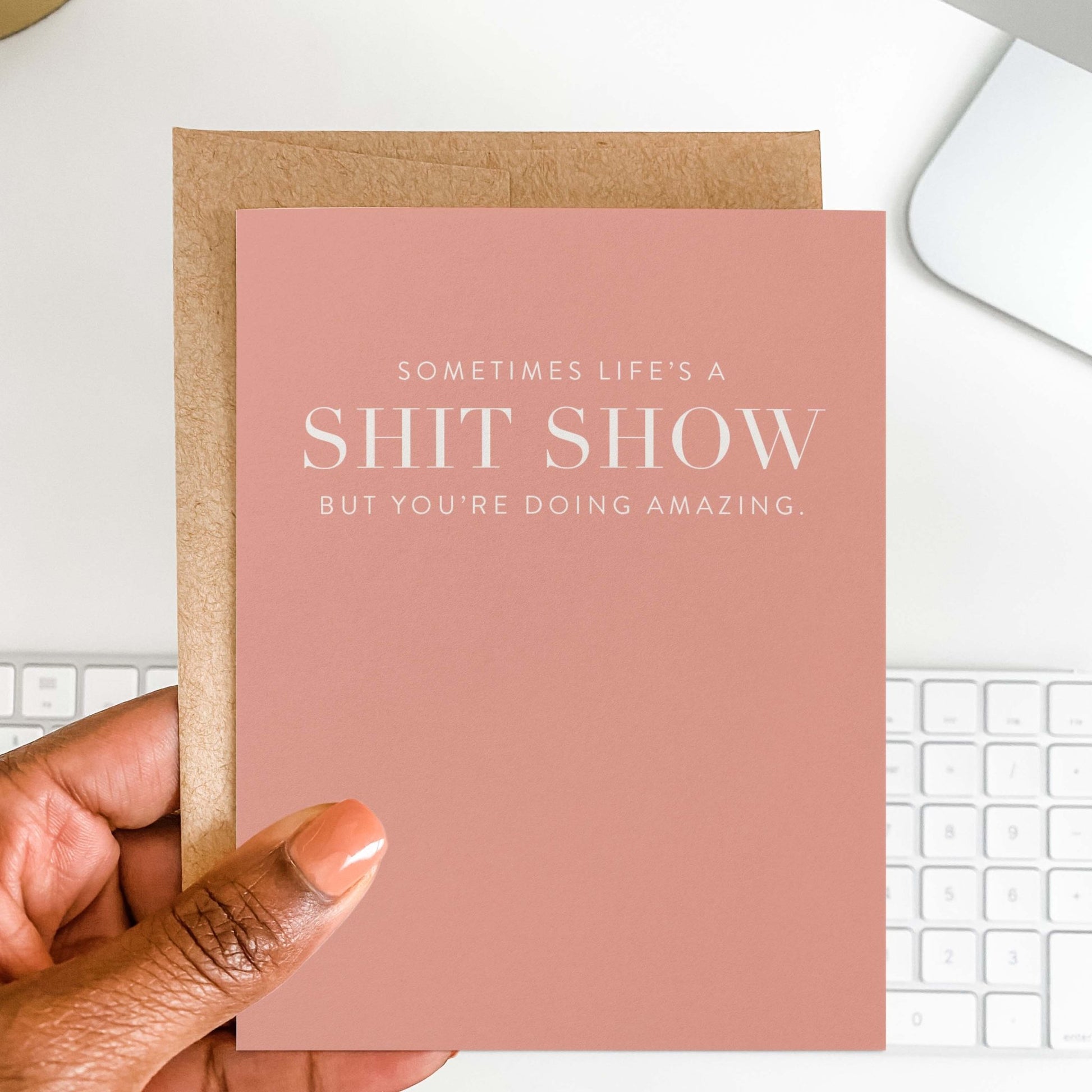 Hand holding pink Life’s A Shit Show funny encouragement greeting card