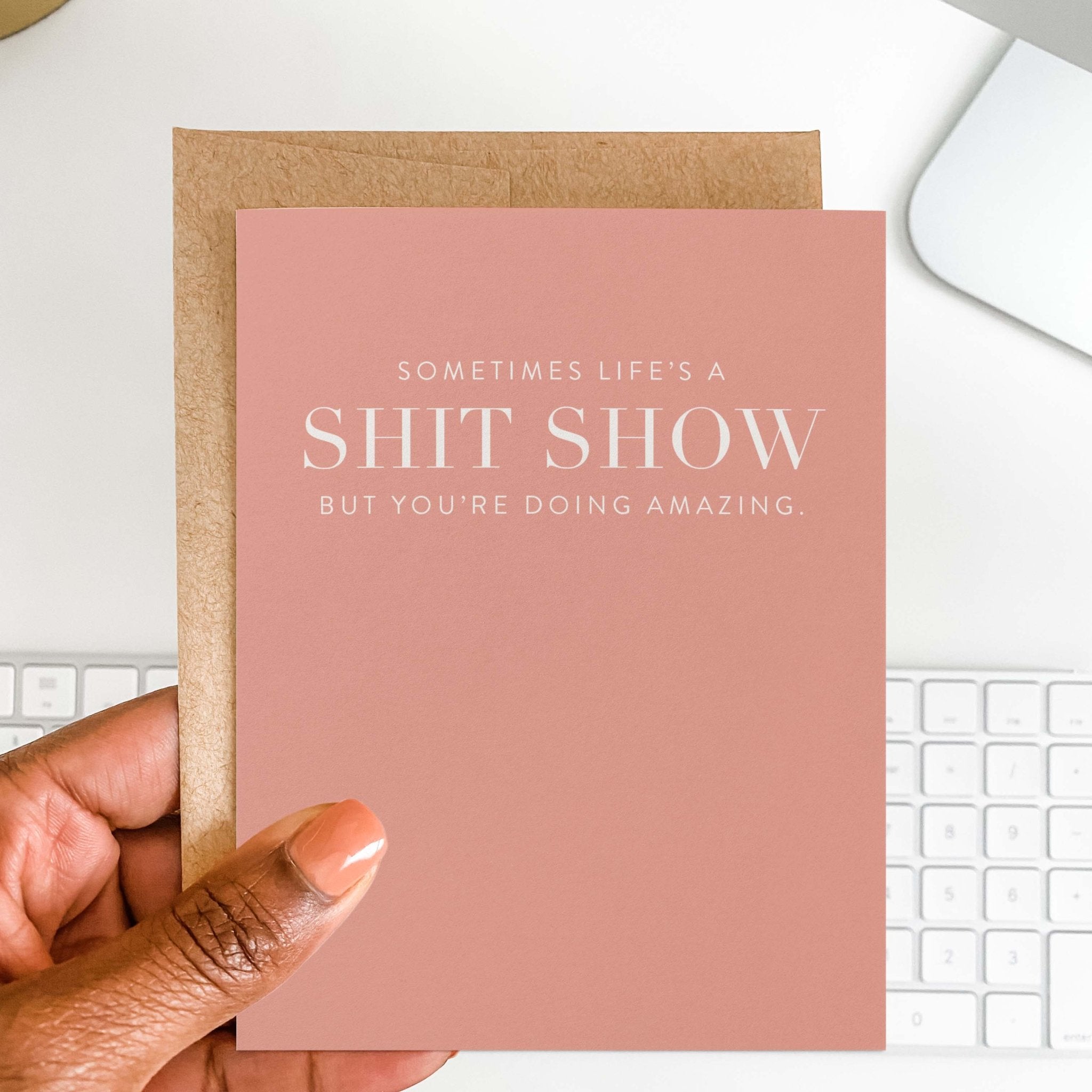 Hand holding pink Life’s A Shit Show funny encouragement greeting card
