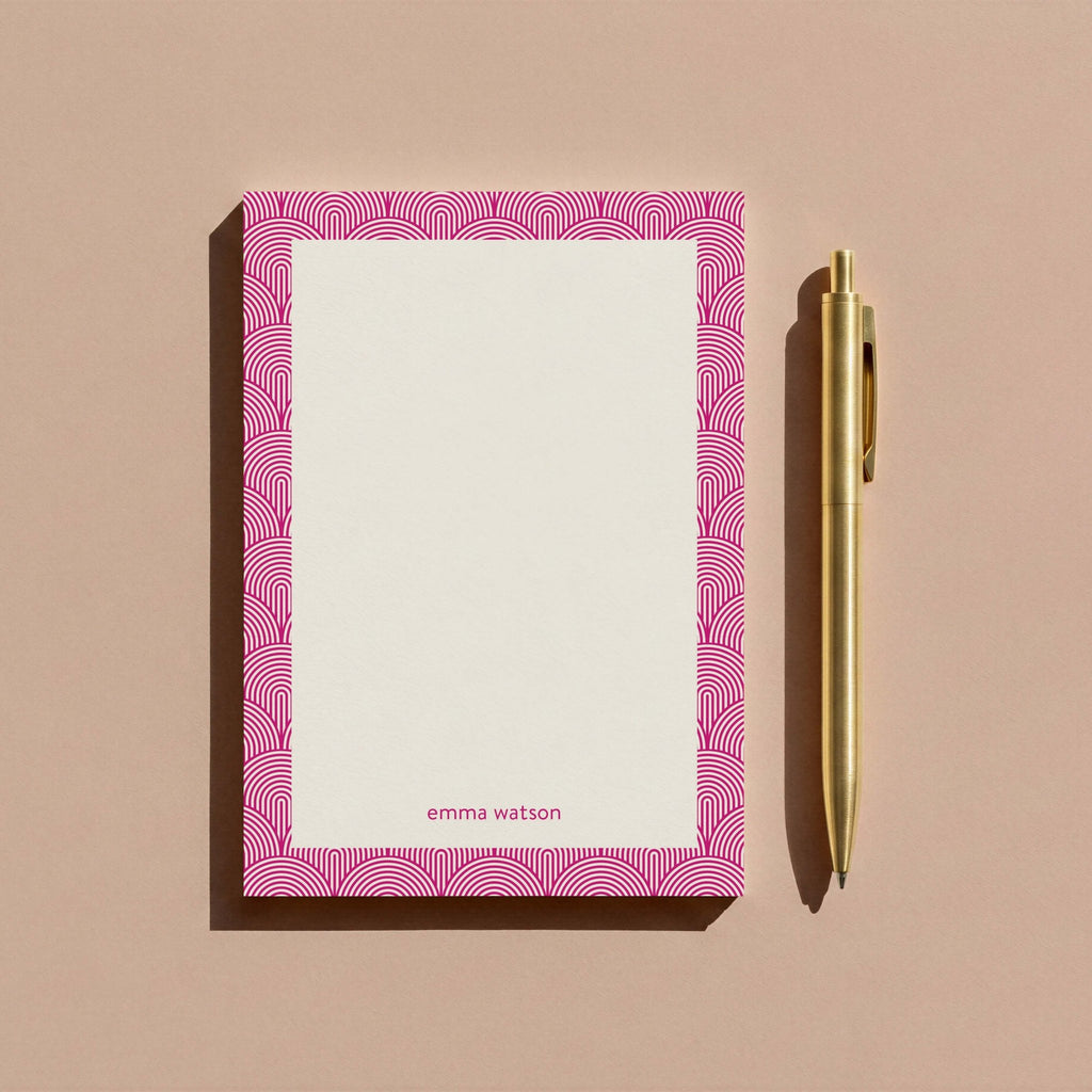 Lined Arches personalized notepad by Blú Rose, magenta arch-bordered notepad photographed with a gold pen on a mauve background