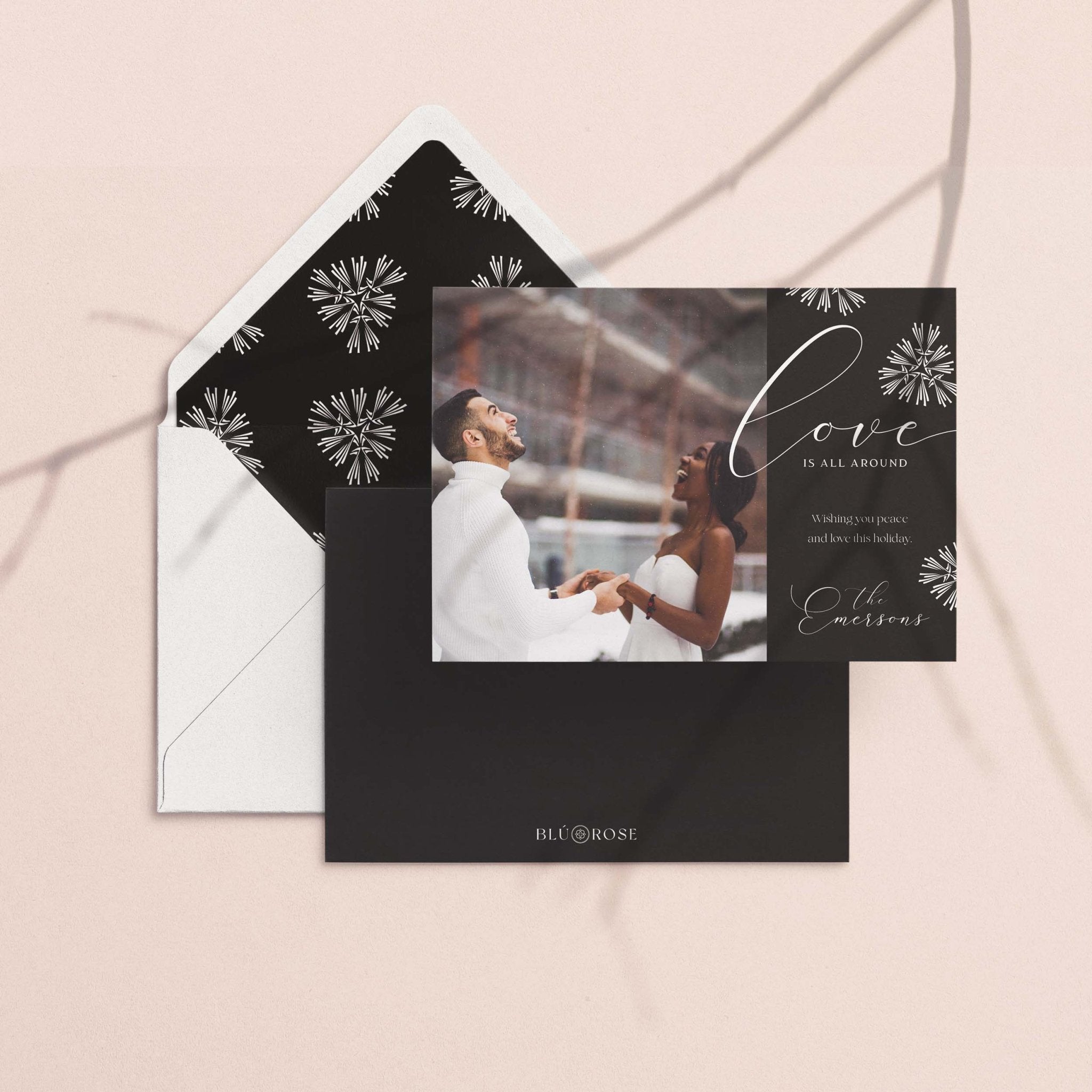Love Is All Around card with its charcoal snowflake envelope liner on a neutral backdrop
