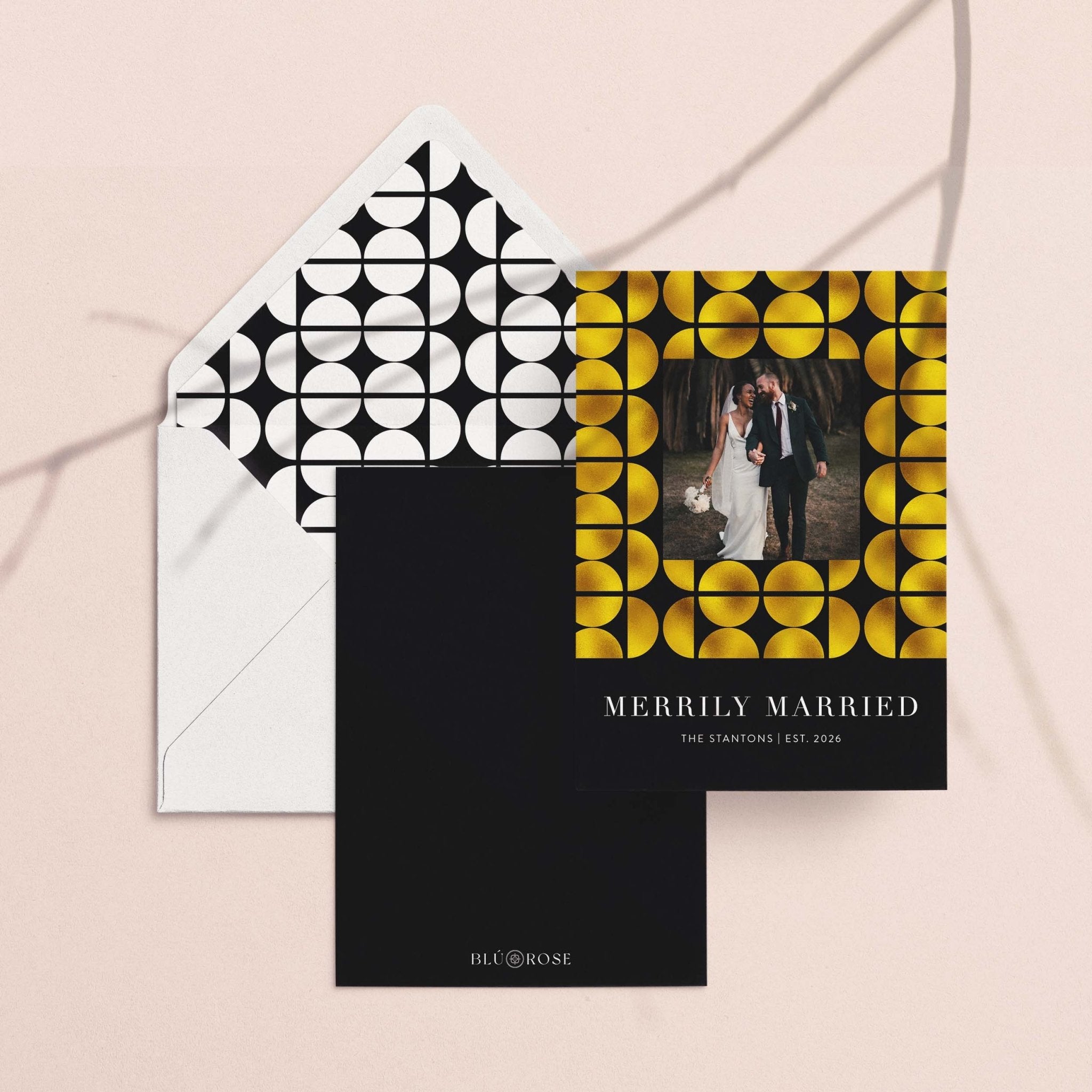 Merrily Married card with its black and white geometric envelope liner on a blush backdrop