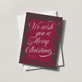 Merry Christmas Plaid holiday card in deep burgundy with white calligraphy reading We wish you a Merry Christmas