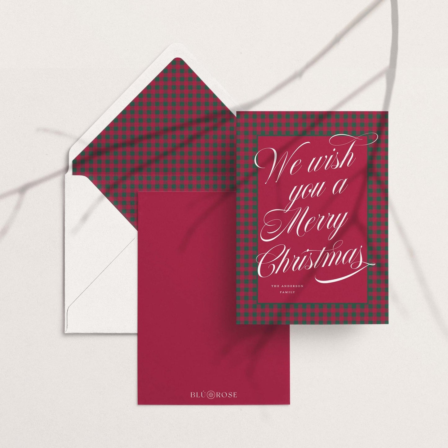 Red and green plaid custom holiday card paired with matching patterned envelope liner on white envelope and red backing.