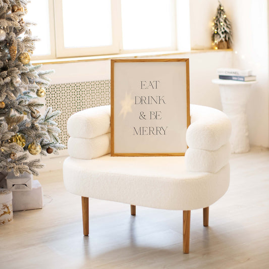 Minimal Eat Drink & Be Merry wall art styled on a chair in a neutral living space