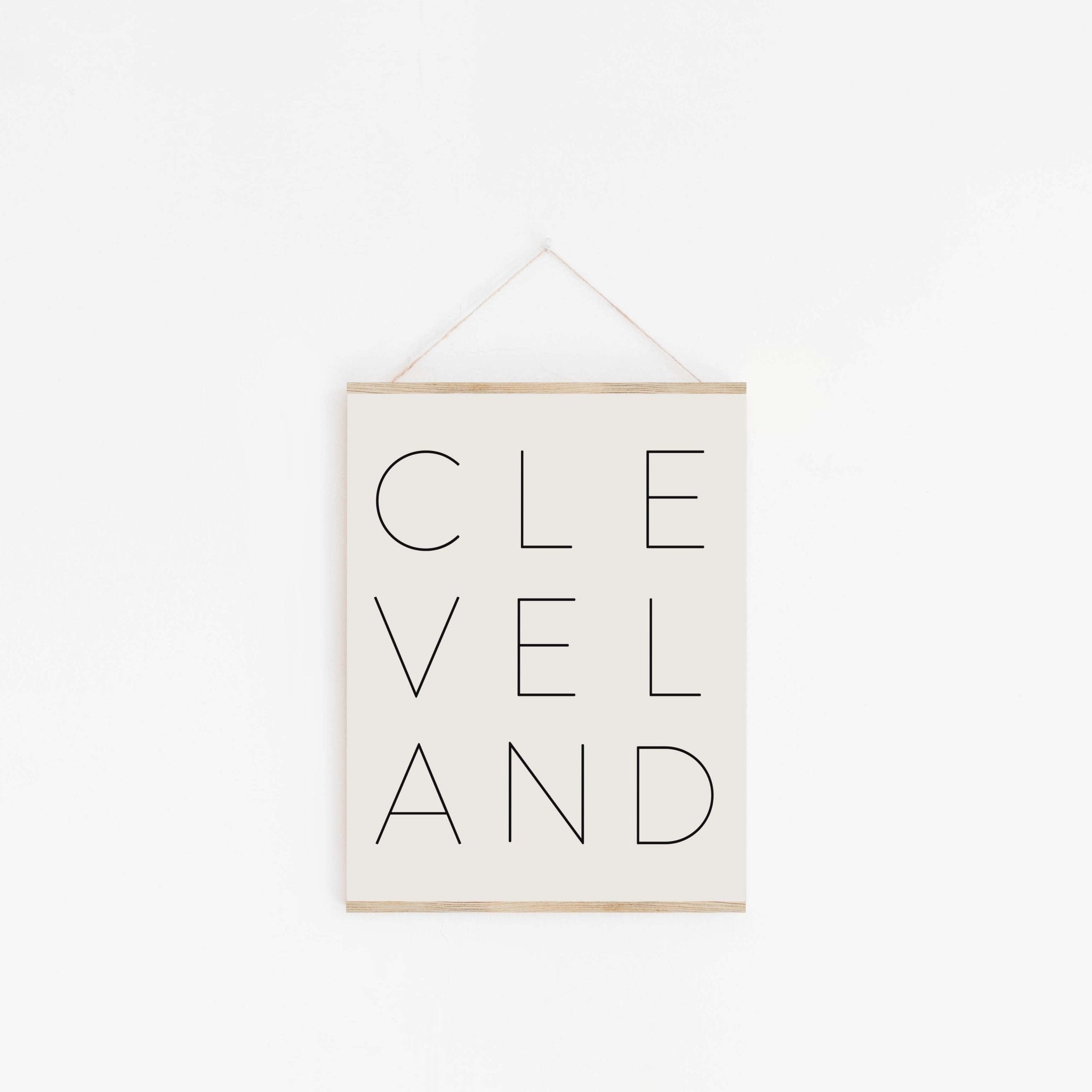 Cleveland typography wall art hanging from wood hanger with minimalist design