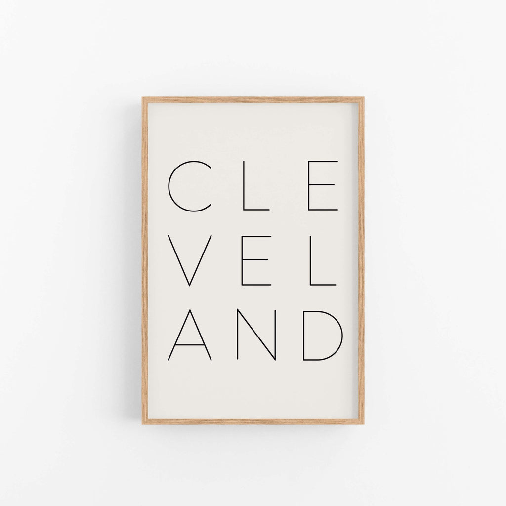 Modern Cleveland wall art print in light wood frame with clean typography design