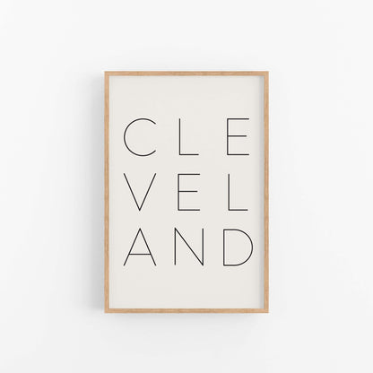 Modern Cleveland wall art print in light wood frame with clean typography design