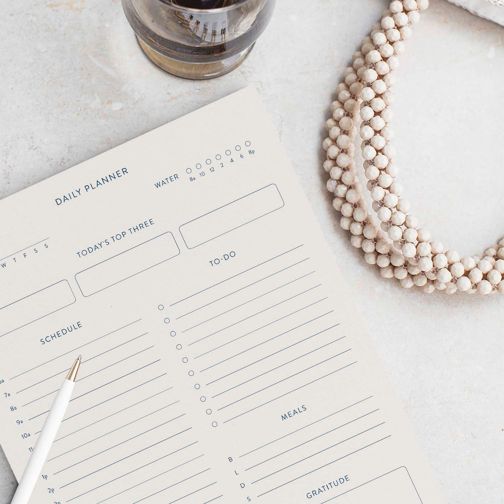 Minimalist Daily Planner notepad by Blú Rose, blank daily planner page styled with a white pen and beaded necklace