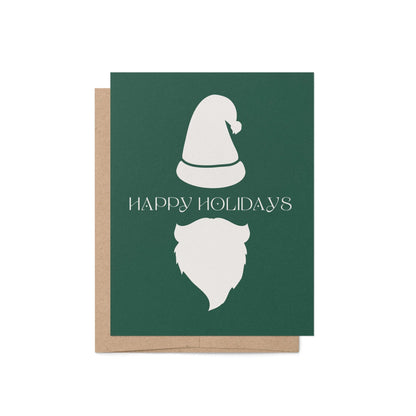 Modern Santa holiday greeting card with minimalist white hat and beard on green background, paired with kraft envelope