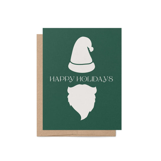 Modern Santa holiday greeting card with minimalist white hat and beard on green background, paired with kraft envelope