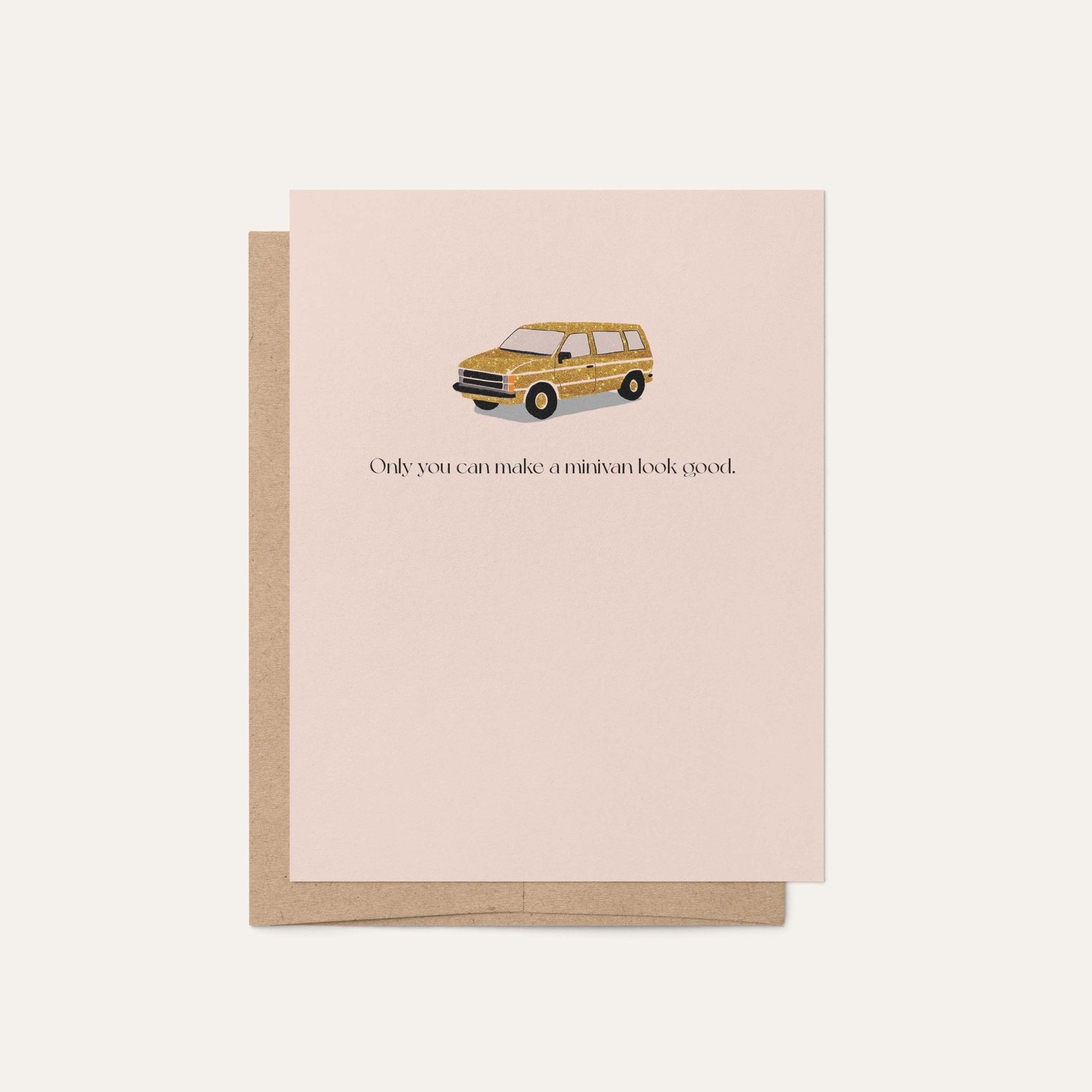Blush pink greeting card featuring a illustrated faux gold minivan with the text 'Only you can make a minivan look good,' displayed with a kraft brown envelope on a light neutral background.
