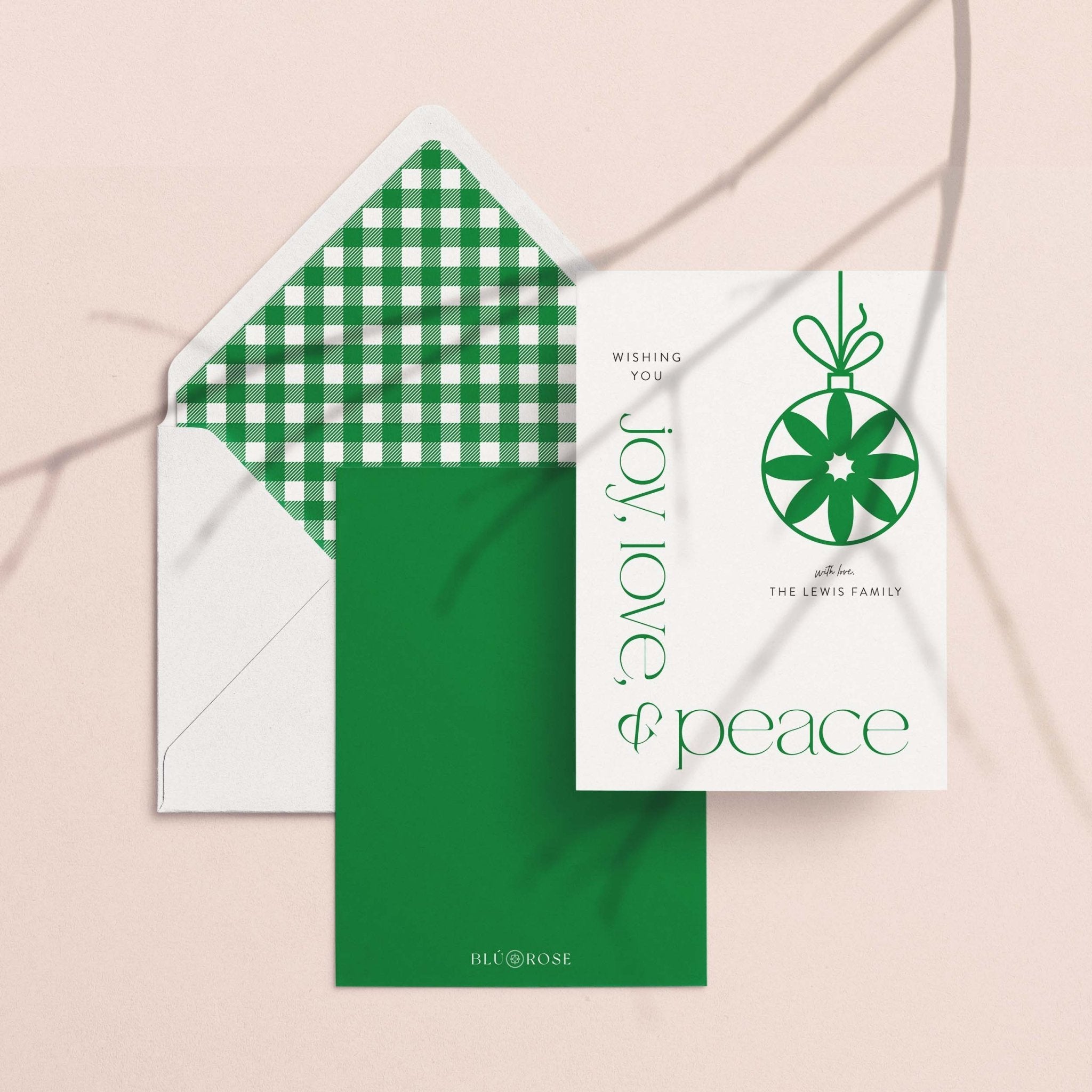 Modern Ornament card with its green gingham envelope liner styled on a blush backdrop