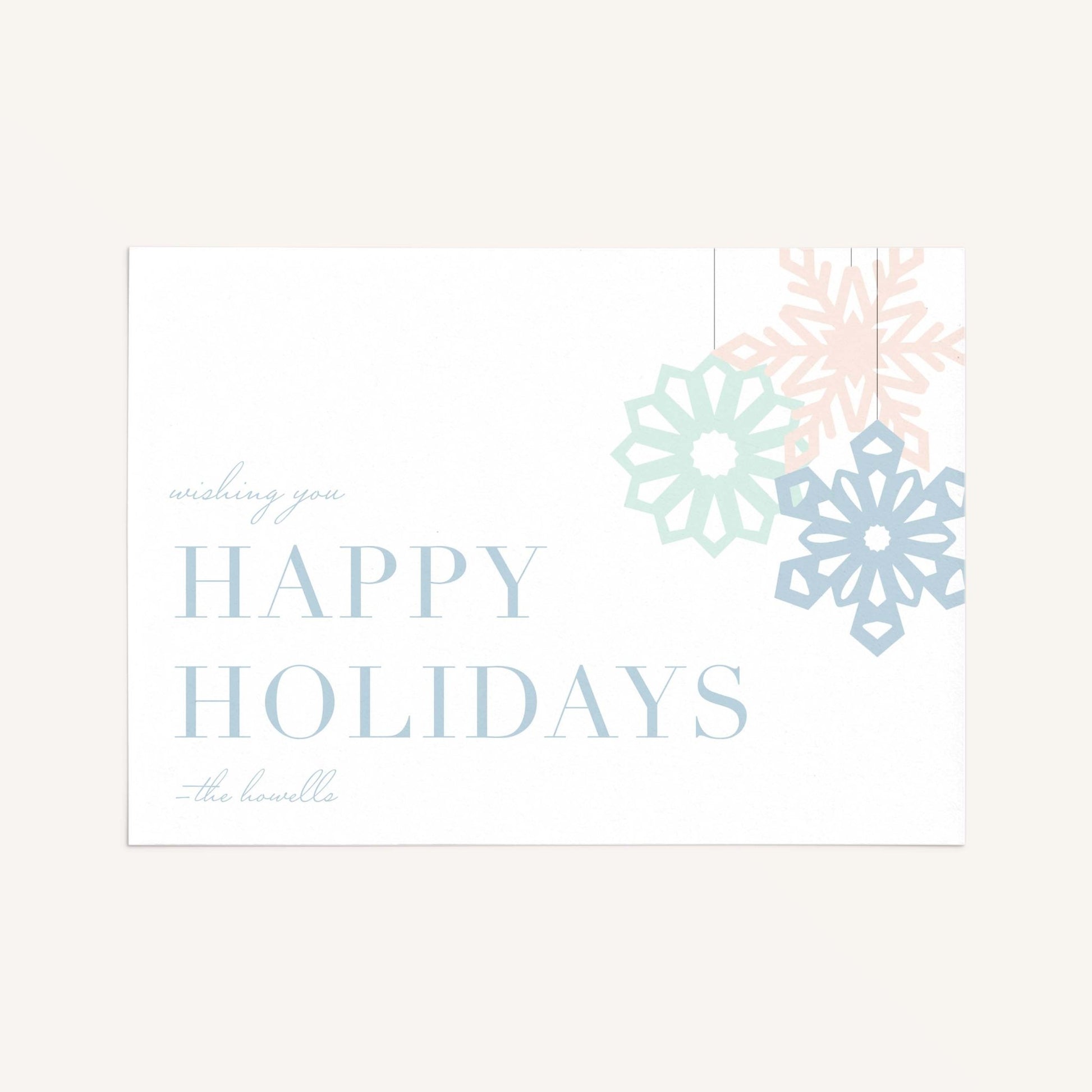Modern snowflake holiday card with pastel snowflakes and “Happy Holidays” message on a clean neutral background.