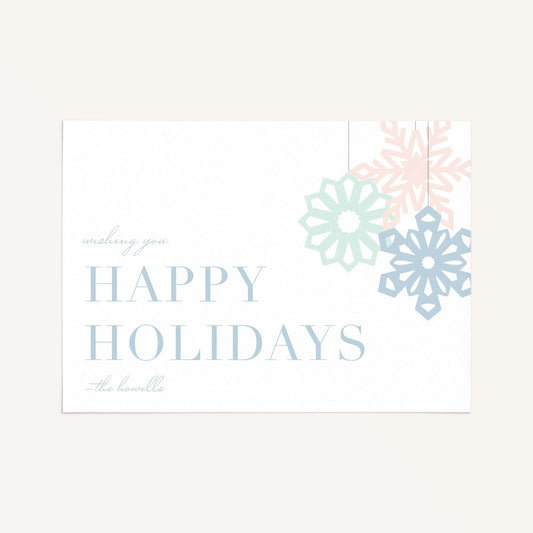 Modern snowflake holiday card with pastel snowflakes and “Happy Holidays” message on a clean neutral background.