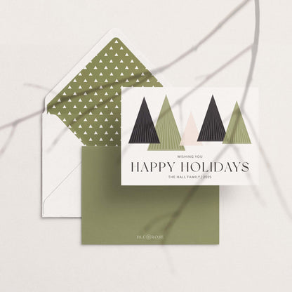 Holiday card with geometric tree design and matching envelope liner on a neutral surface.
