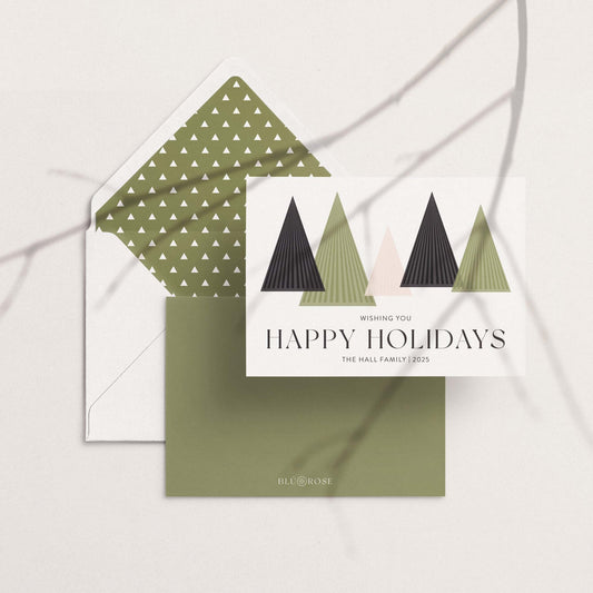 Holiday card with geometric tree design and matching envelope liner on a neutral surface.