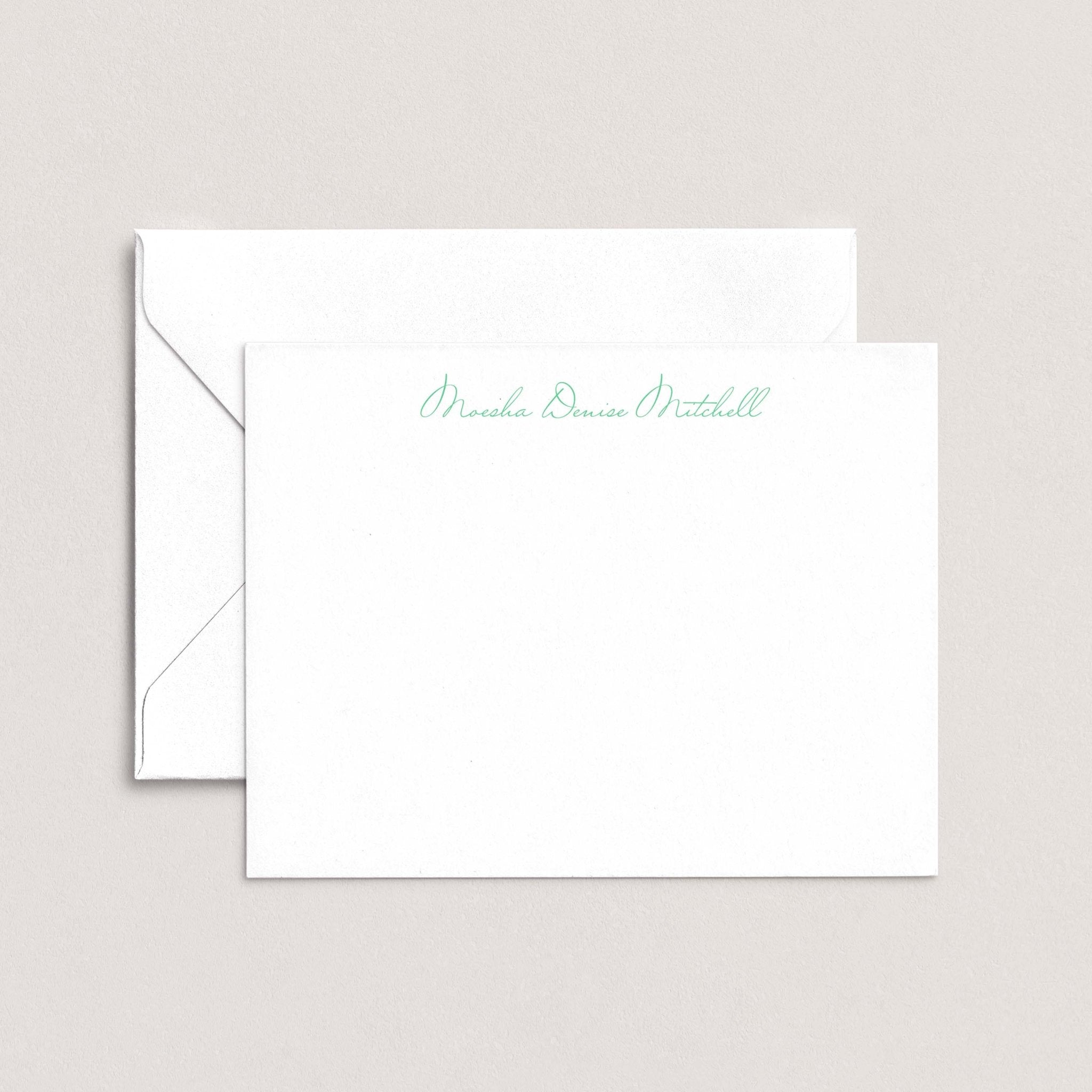Moesha personalized notecards by Blú Rose, white flat notecard with the name 'Moesha Denise Mitchell' in green script, shown with a coordinating white envelope