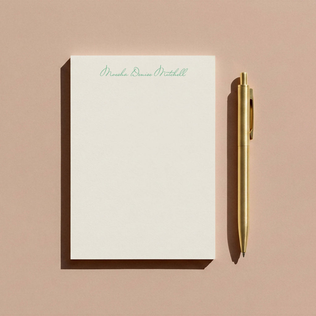 Moesha personalized notepad by Blú Rose, script-name notepad photographed with a gold pen on a mauve background