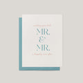 A wedding greeting card with a white front and a teal envelope behind it, printed with the words 'wishing you both MR. & MR. a happily ever after.