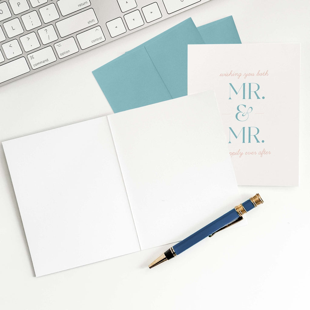 Mr. + Mr. wedding greeting card flat lay with teal envelope and pen